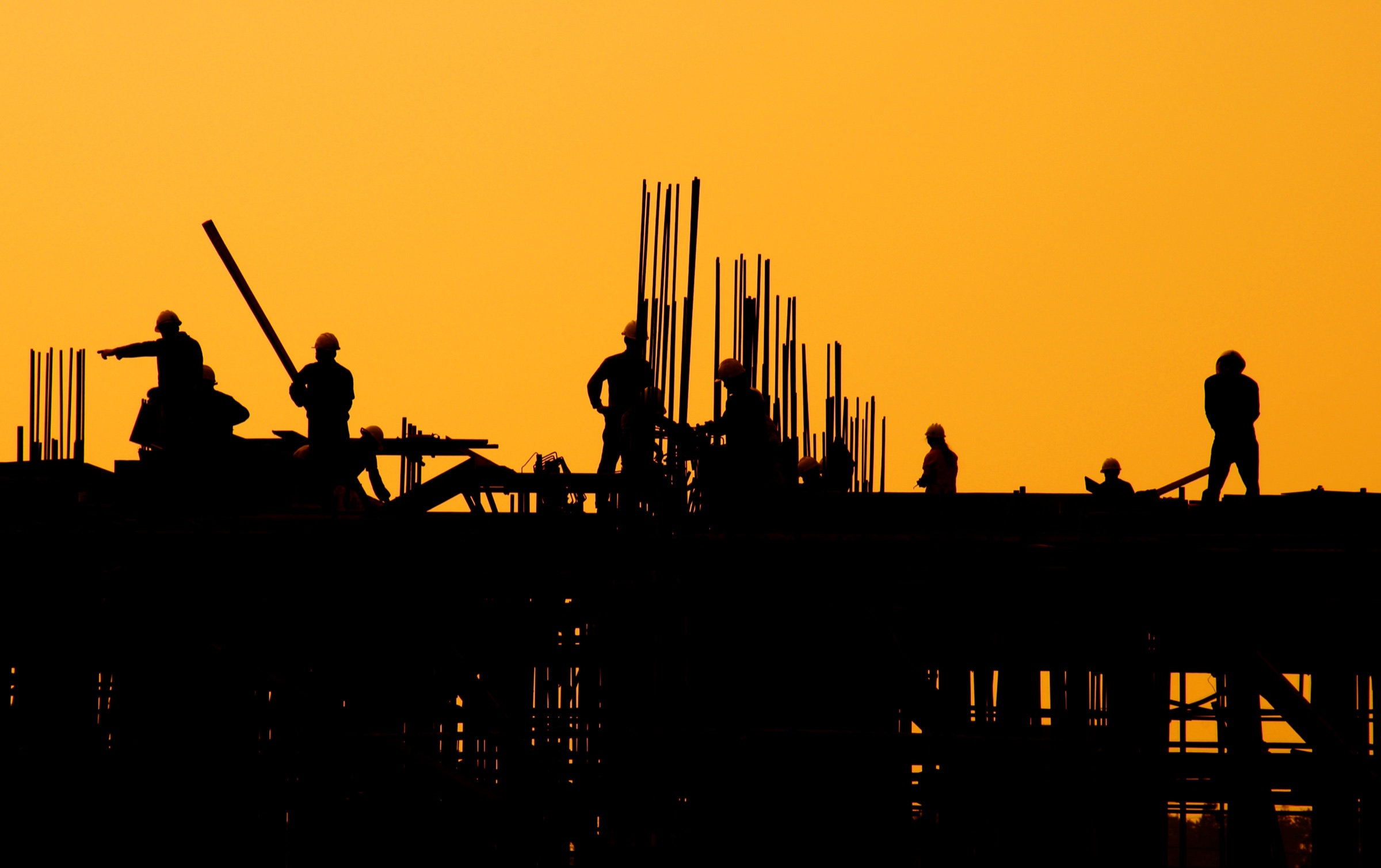 Équipe de construction au travail au coucher du soleil
